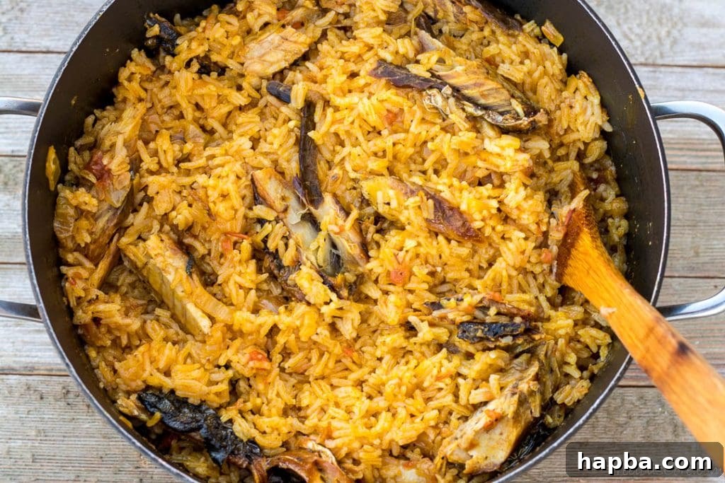 Fluffed palm oil jollof rice ready to be served, showing tender grains.