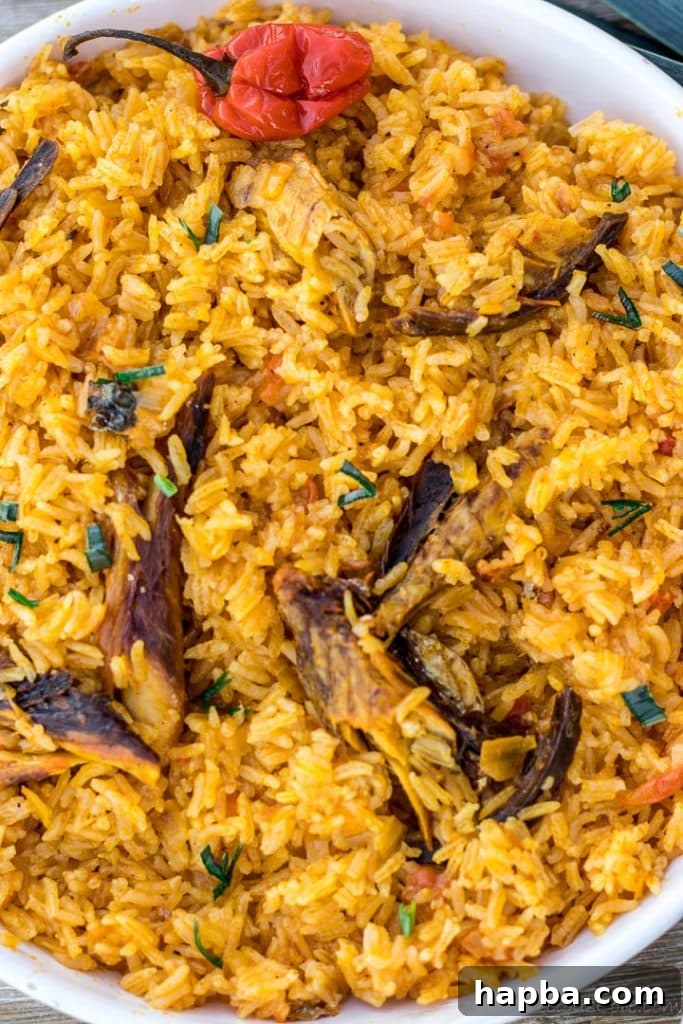 A bowl of native jollof rice, rich with palm oil and crayfish, garnished attractively.