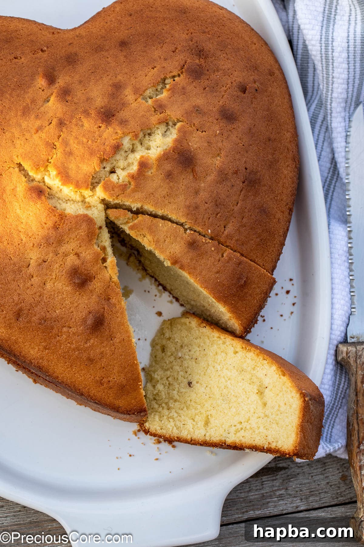A delectable plain cake with several slices already enjoyed, revealing its tender, airy crumb.