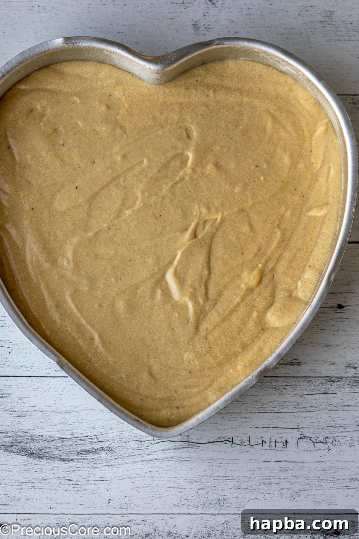 Lush cake batter carefully poured into a charming heart-shaped baking pan, ready for the oven.