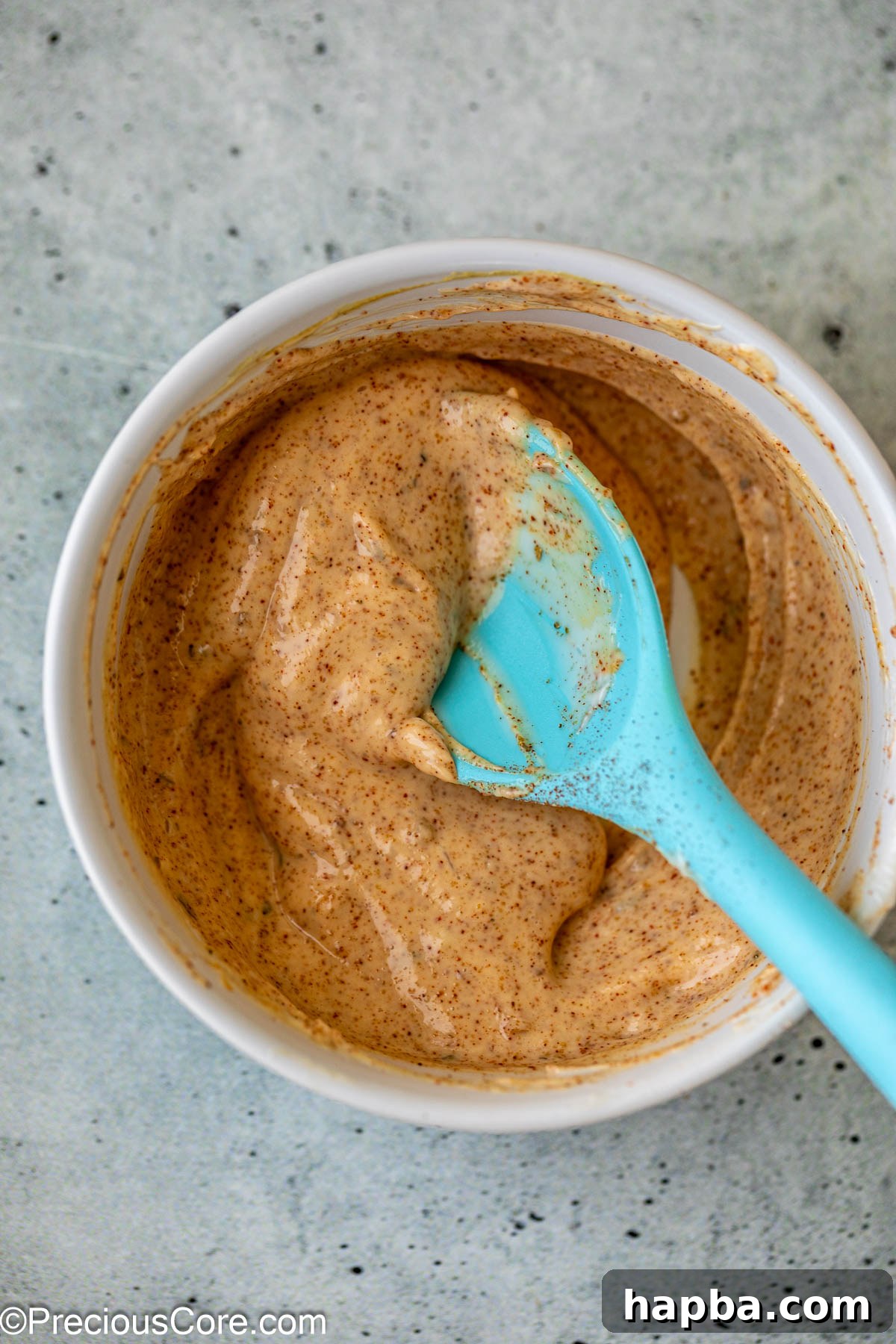 A small bowl containing the mixed mayonnaise sauce, displaying its creamy texture and vibrant color.