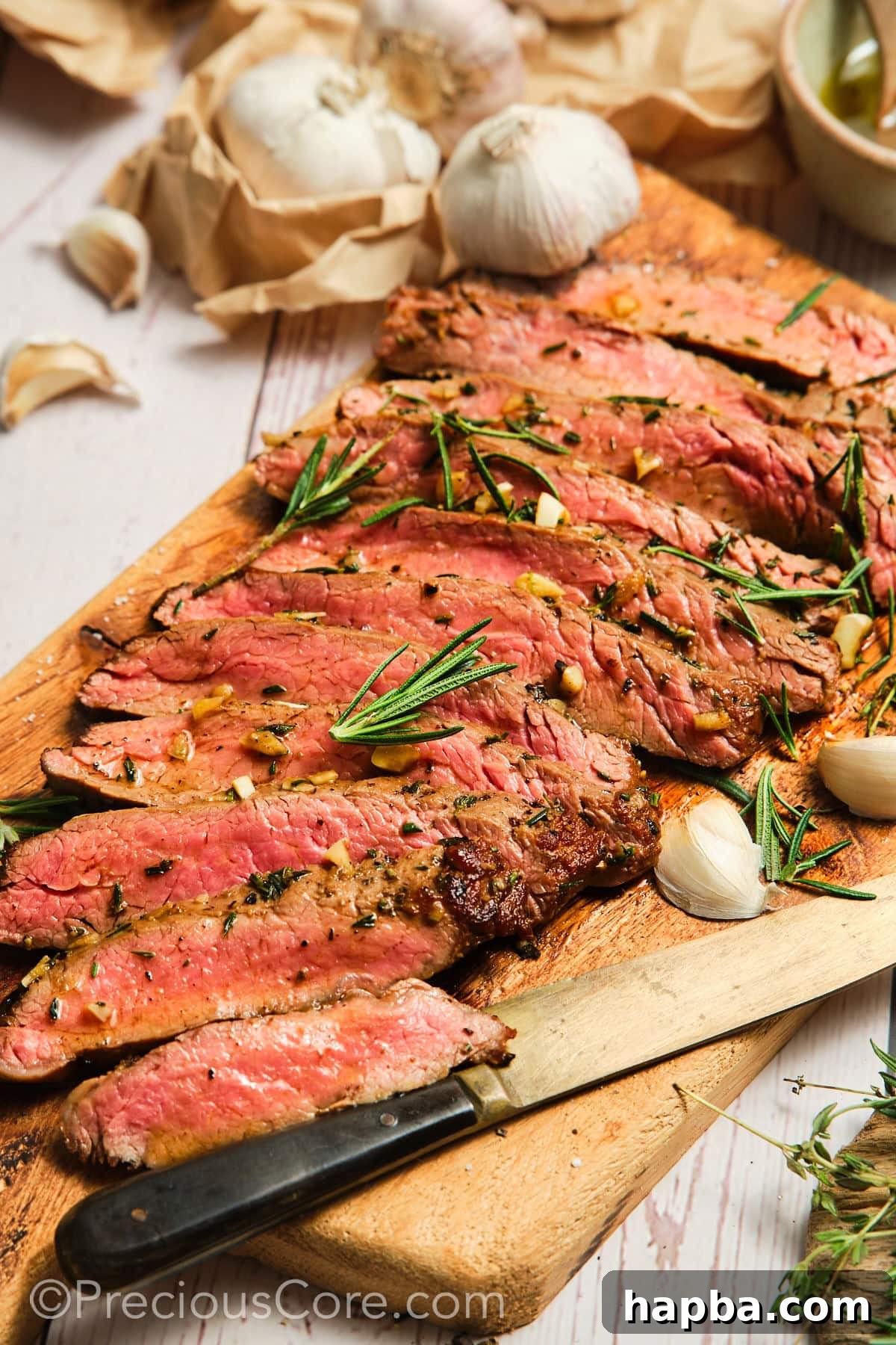 Perfectly sliced pan-seared flank steak arranged on a rustic cutting board, showcasing its juicy, pink center and golden-brown crust.