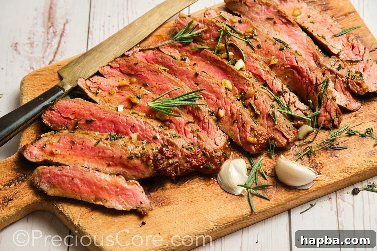 A wide shot of perfectly cooked pan-seared flank steak resting on a cutting board, ready for slicing and serving.