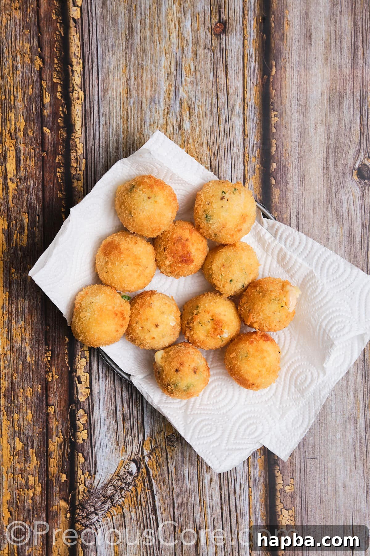 Cheesy potato balls on paper towels.