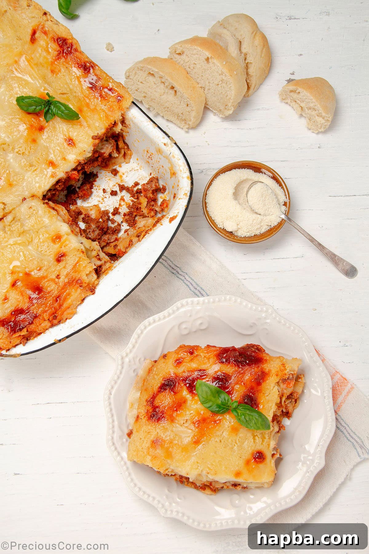 Creamy Béchamel Lasagna 2 A perfectly sliced portion of Lasagna with Béchamel Sauce on a plate, with a freshly baked full dish of lasagna in the background, ready to be served.