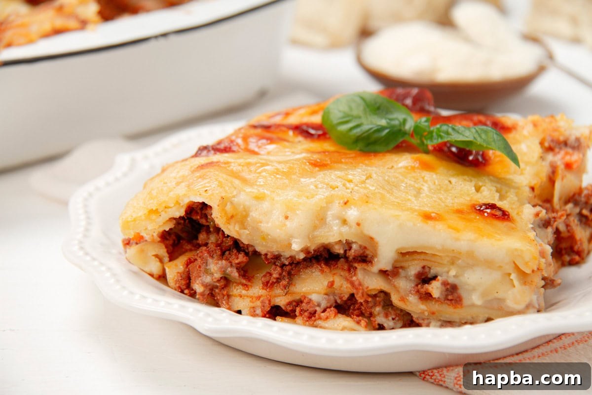 Creamy Béchamel Lasagna 15 A close-up, mouth-watering image of a slice of perfectly baked lasagna made with béchamel sauce, showing its distinct layers of pasta, meat, and creamy white sauce.