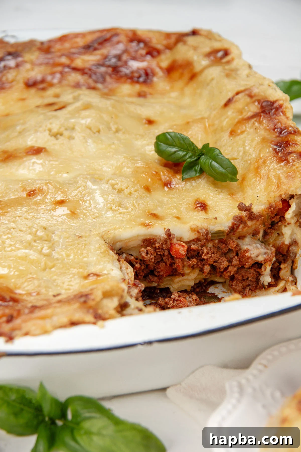 Creamy Béchamel Lasagna 3 Close-up view of a baked dish of classic lasagna with béchamel sauce, showcasing its golden-brown top and bubbling edges.
