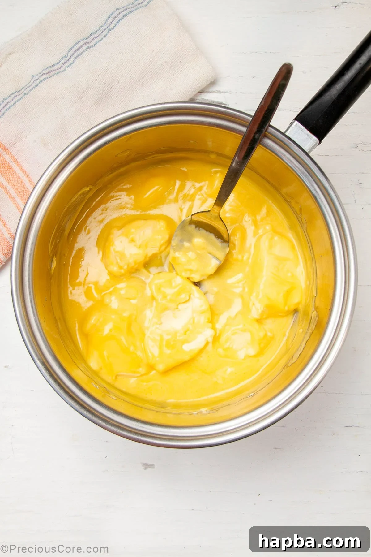 Creamy Béchamel Lasagna 7 Butter melting in a silver saucepan over a stovetop, forming a clear yellow liquid.