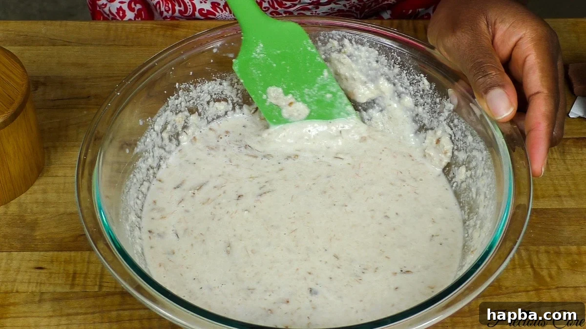 Adding smoked meat and fish to egusi mixture