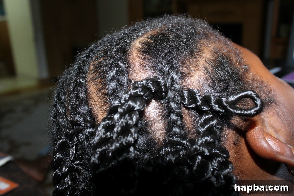 Crochet hook pulling looped hair through a cornrow