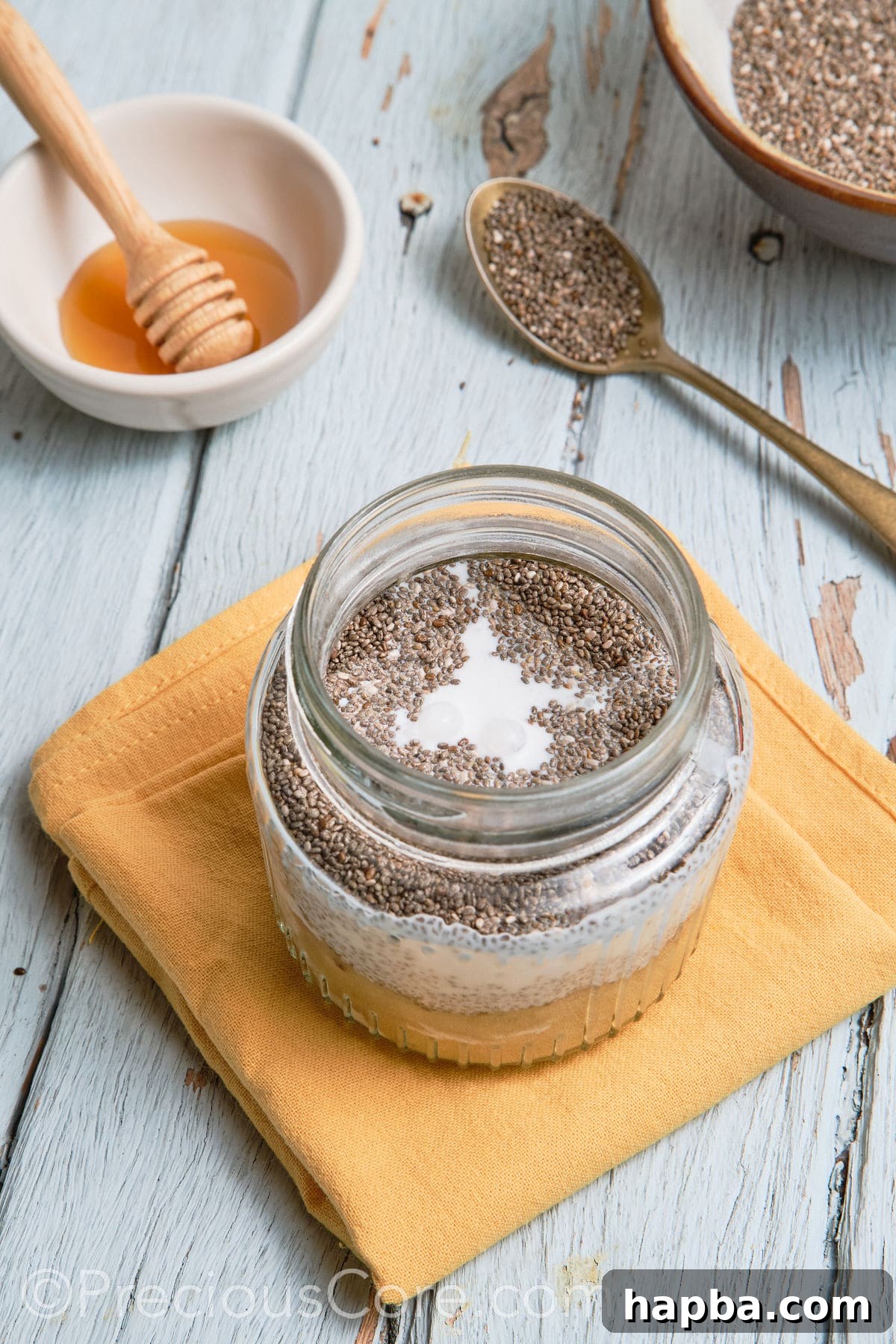 The banana chia pudding mixture in a glass jar, after all ingredients have been combined and stirred.