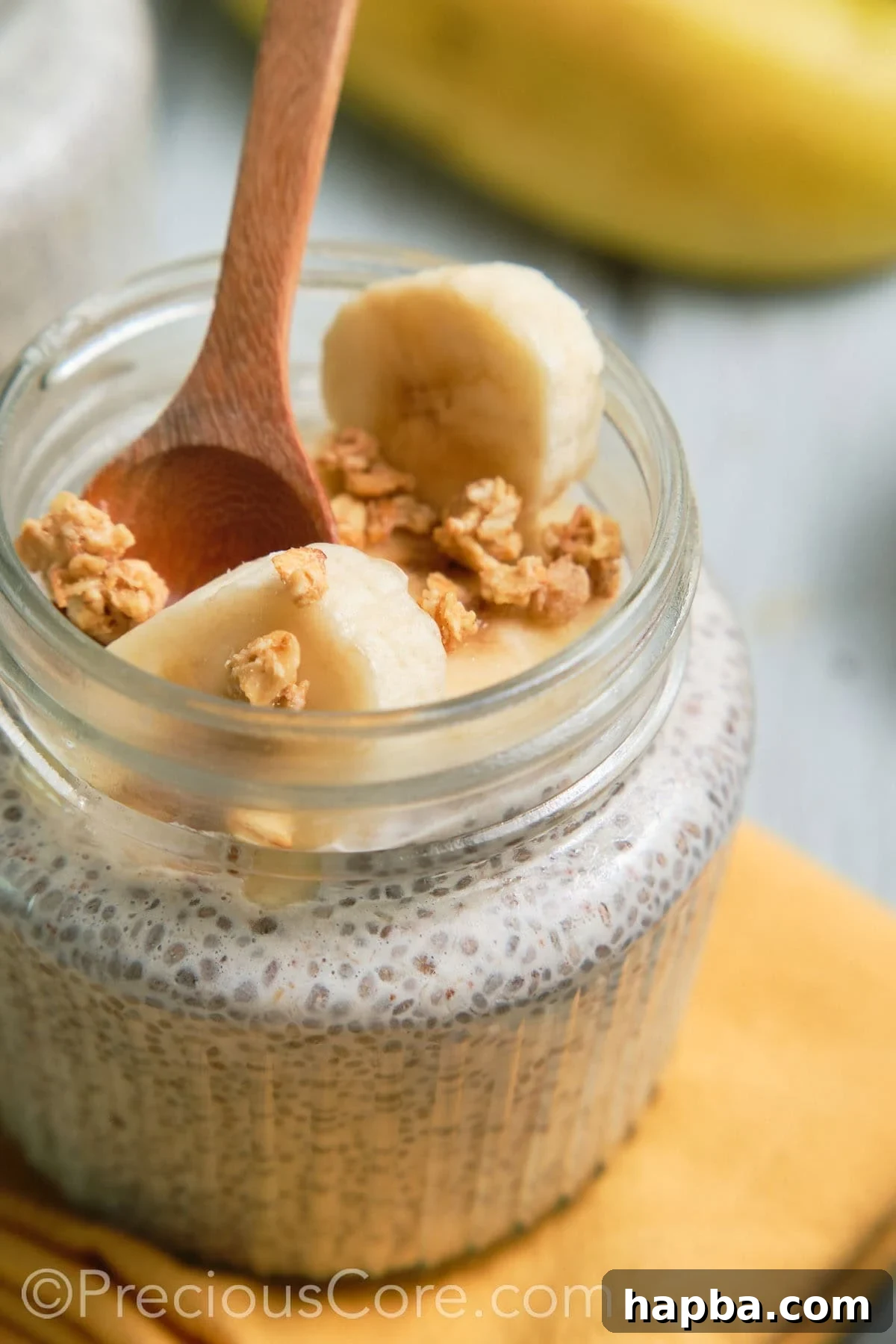 A spoon elegantly dipped into a jar of banana chia pudding, ready to be enjoyed.