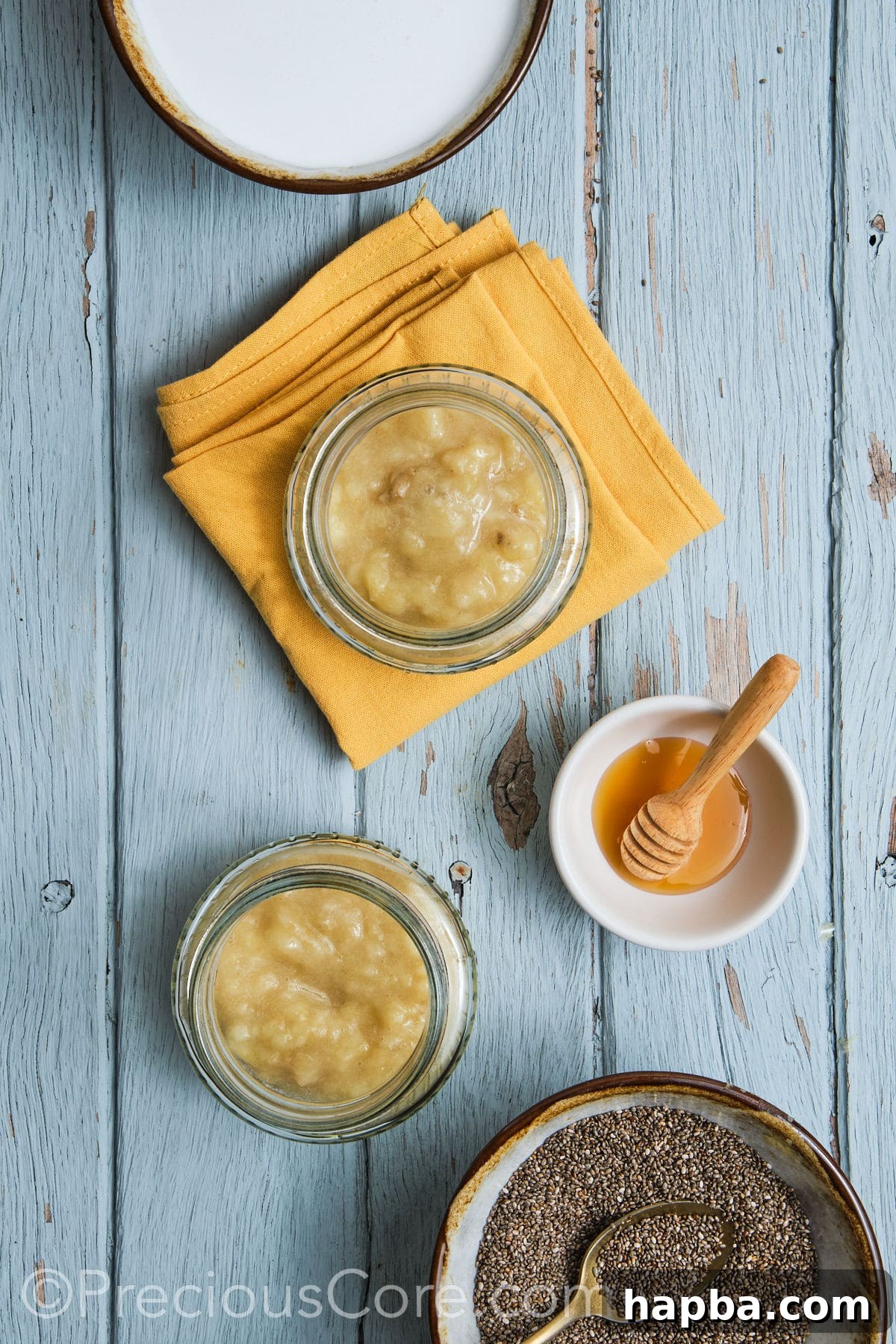 Mashed bananas being transferred into glass jars, preparing for the next steps.