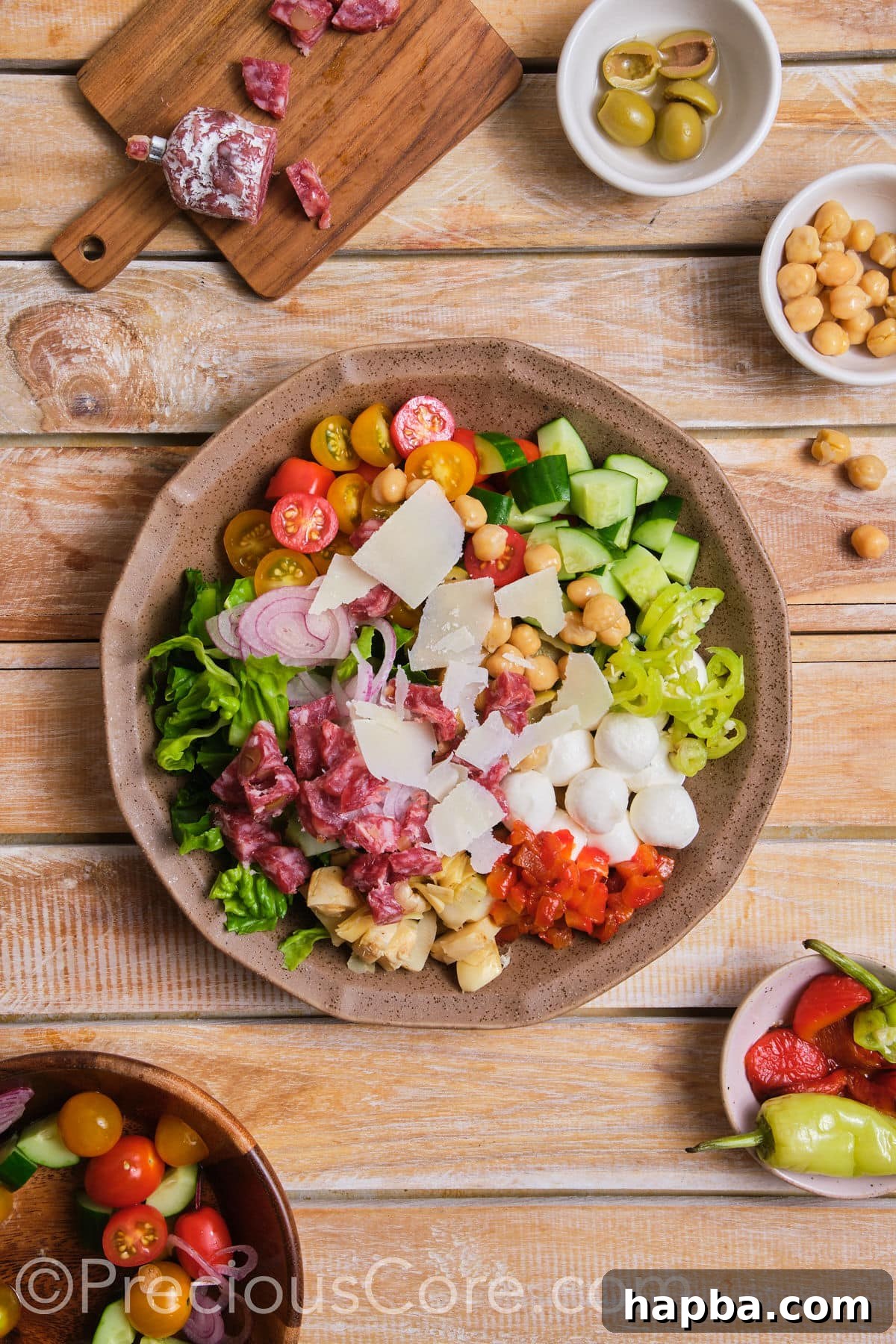 A large bowl containing a vibrant mix of fresh salad ingredients before dressing.