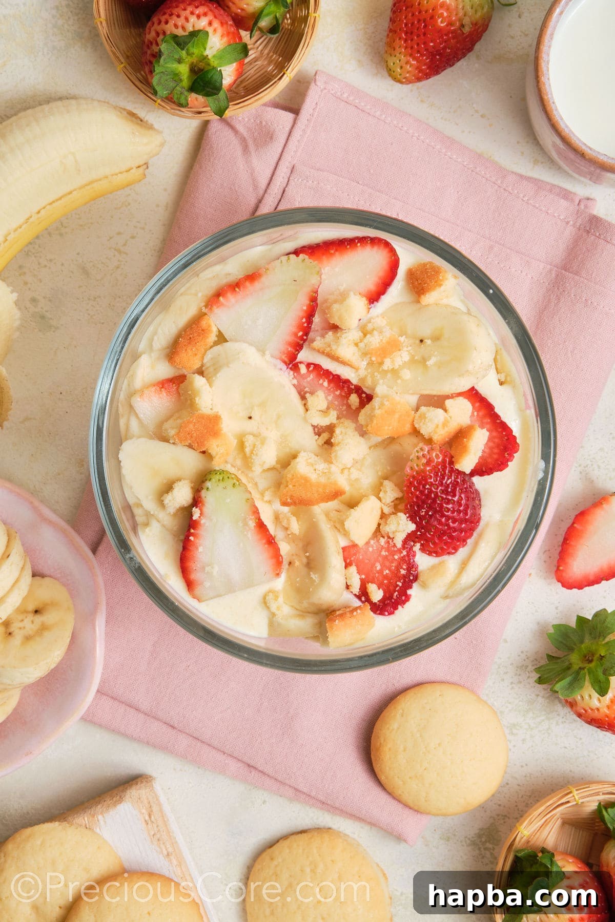Banana pudding topped with strawberries and vanilla wafers.