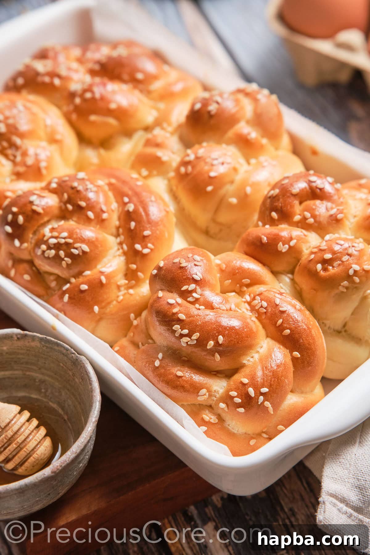 Golden Challah Dinner Buns 2 A baking dish of baked Challah Dinner Rolls, showcasing their golden-brown crust and inviting appearance.