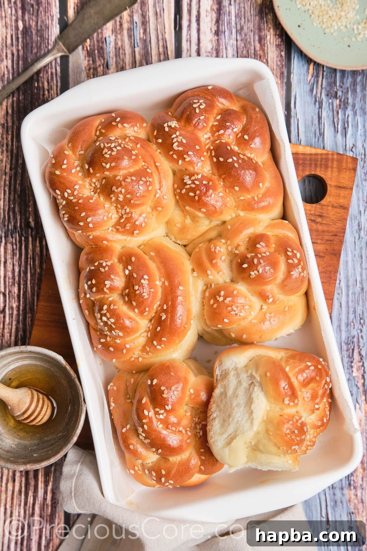 Golden Challah Dinner Buns 14 A single challah roll pulled apart to showcase its soft, airy, and fluffy interior.