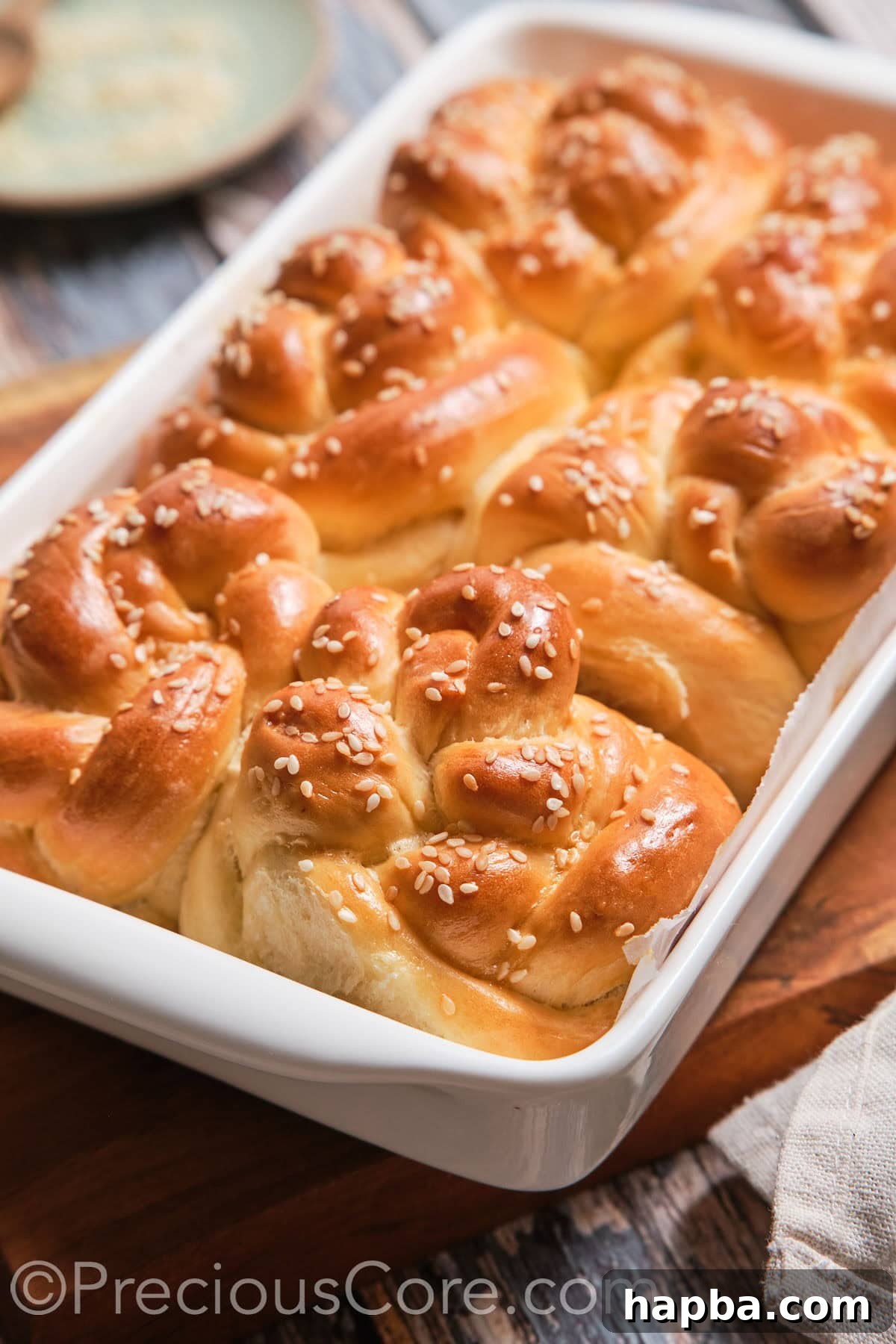 Golden Challah Dinner Buns 15 A pristine baking dish filled with a fresh batch of baked homemade challah rolls.