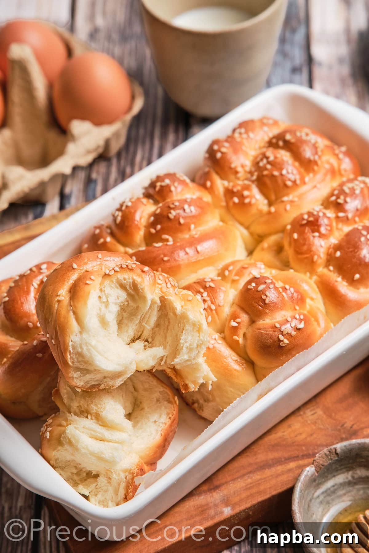 Golden Challah Dinner Buns 3 A Challah roll cut in half to reveal its soft, airy, and pillowy interior texture.