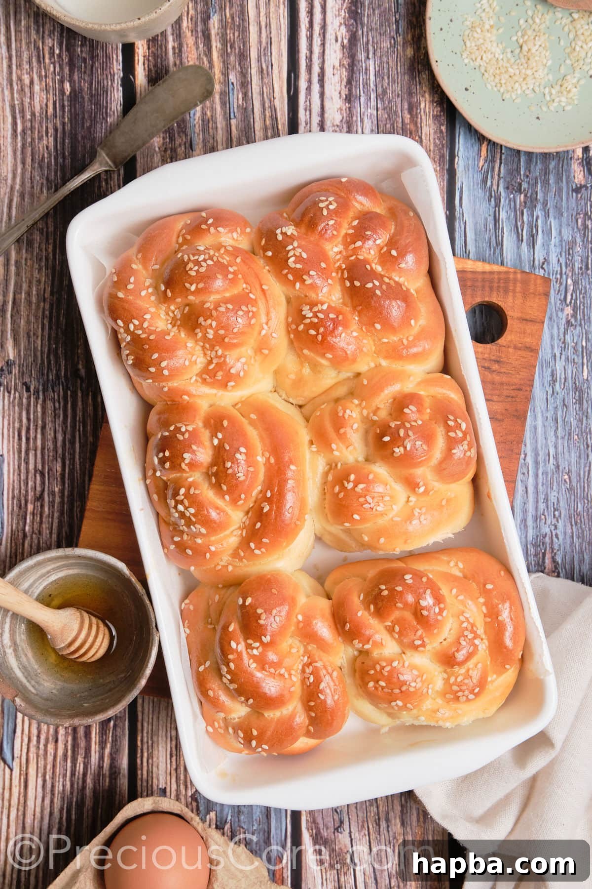 Golden Challah Dinner Buns 4 A close-up shot of golden-brown baked challah twists arranged beautifully.