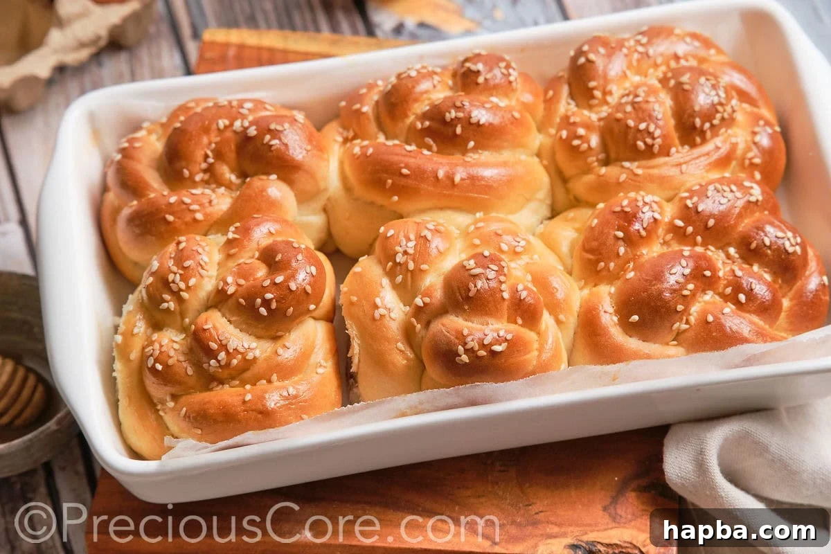 Golden Challah Dinner Buns 6 A wide, landscape image of numerous perfectly baked challah dinner rolls, golden and inviting.