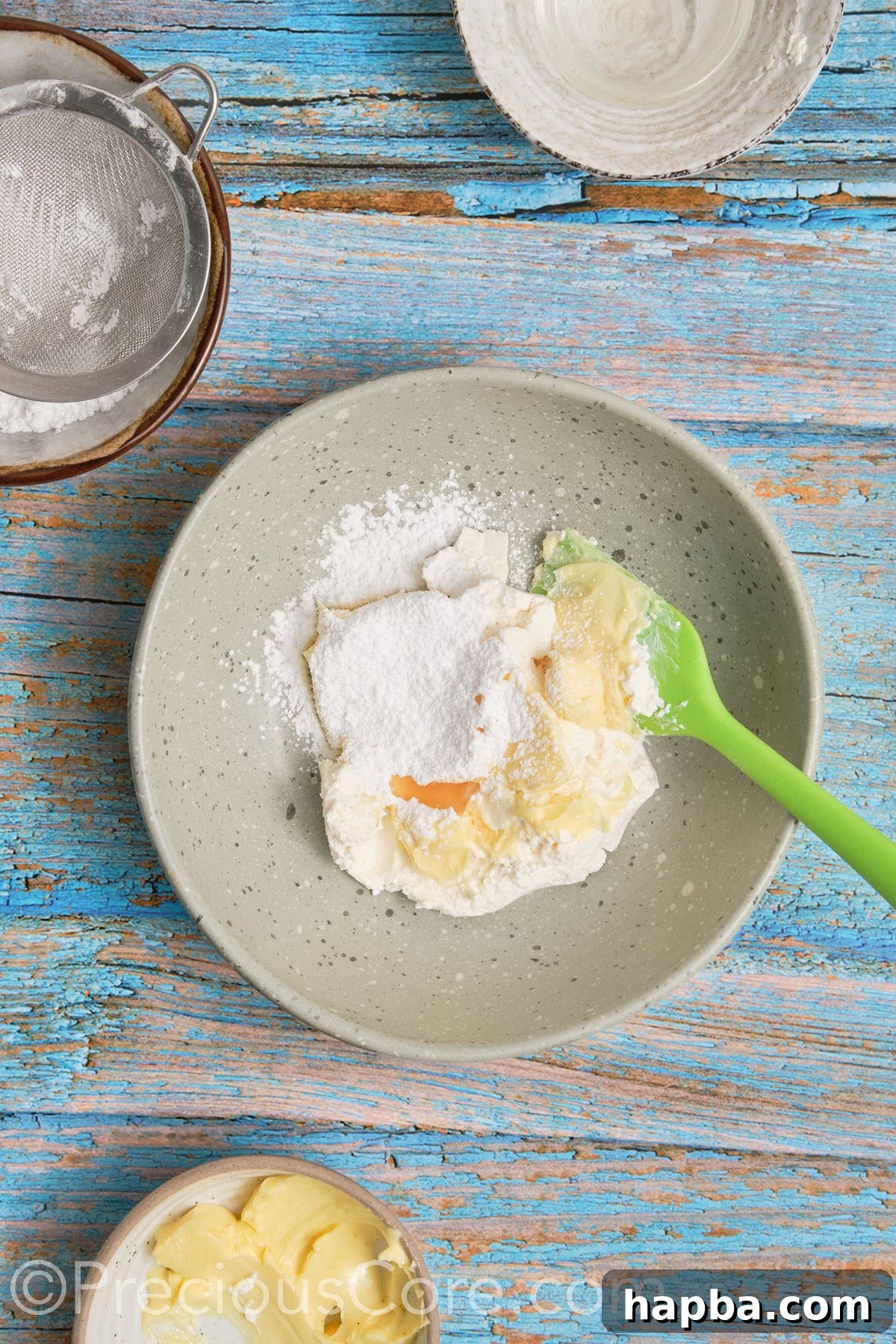 Ingredients for cream cheese frosting – softened cream cheese, butter, powdered sugar, and vanilla extract – in a bowl before mixing.