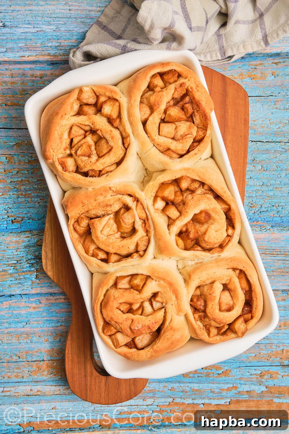 Freshly baked Cinnamon Rolls with Apple Pie Filling, golden brown and glistening, awaiting their creamy frosting.