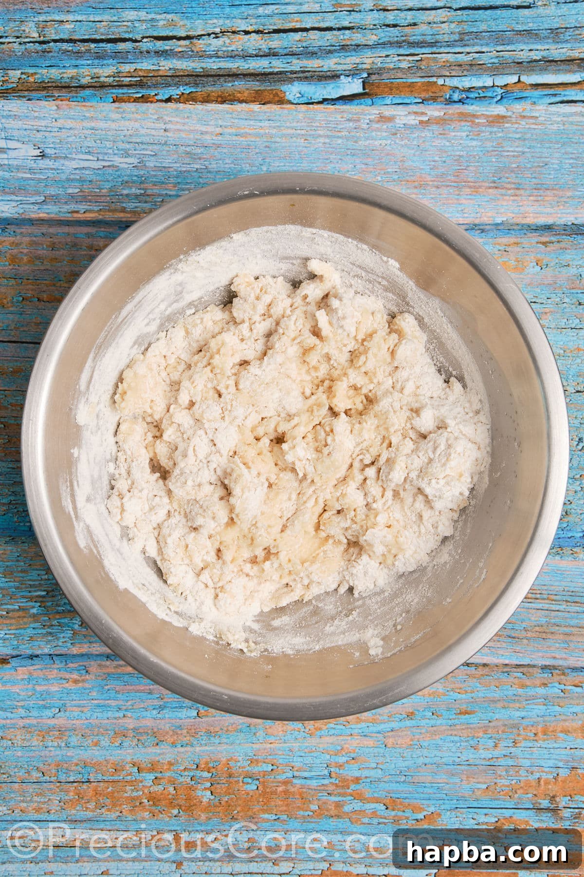 Mixing flour into the wet ingredients to form the dough for homemade cinnamon rolls.