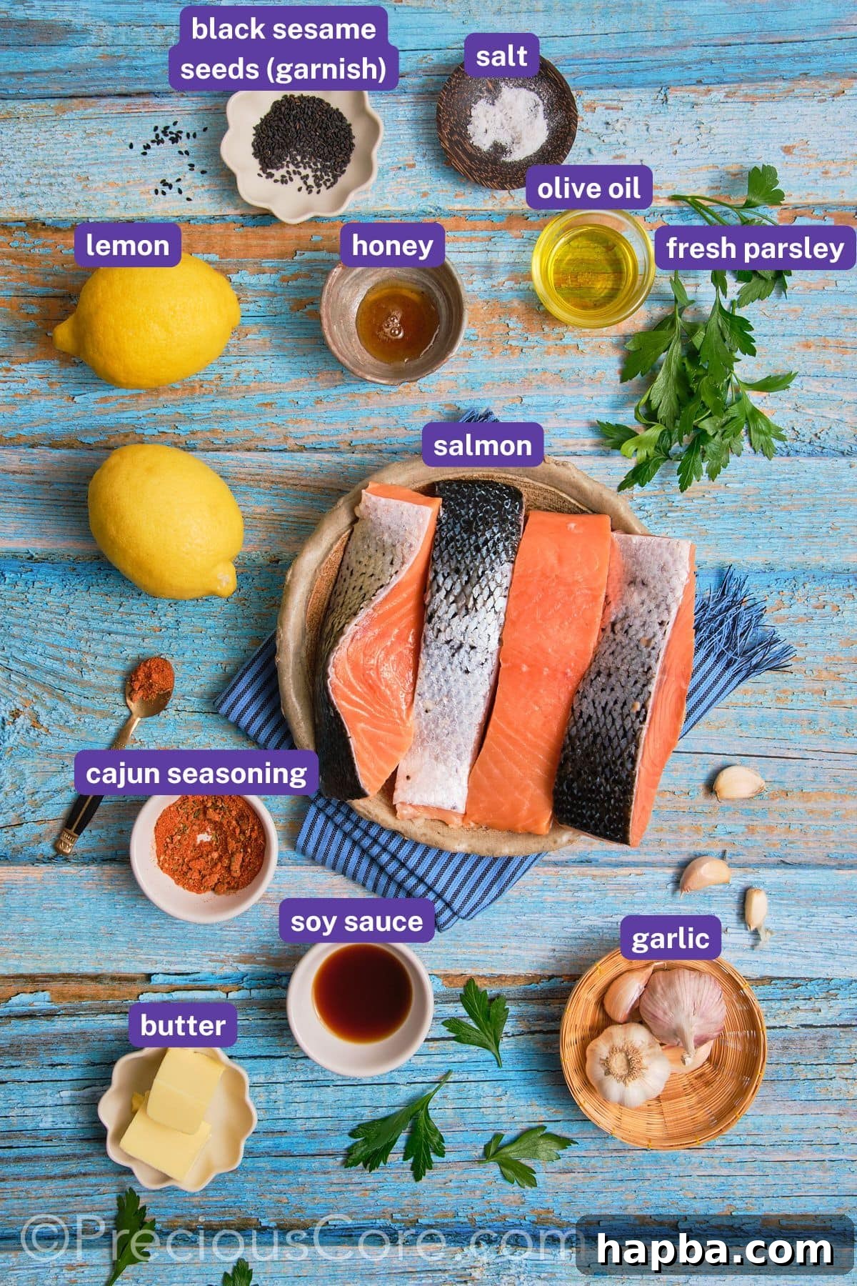 A flat lay of all ingredients for Cajun Honey Butter Salmon: salmon fillets, olive oil, honey, Cajun seasoning, butter, soy sauce, garlic, lemon, parsley, and sesame seeds.