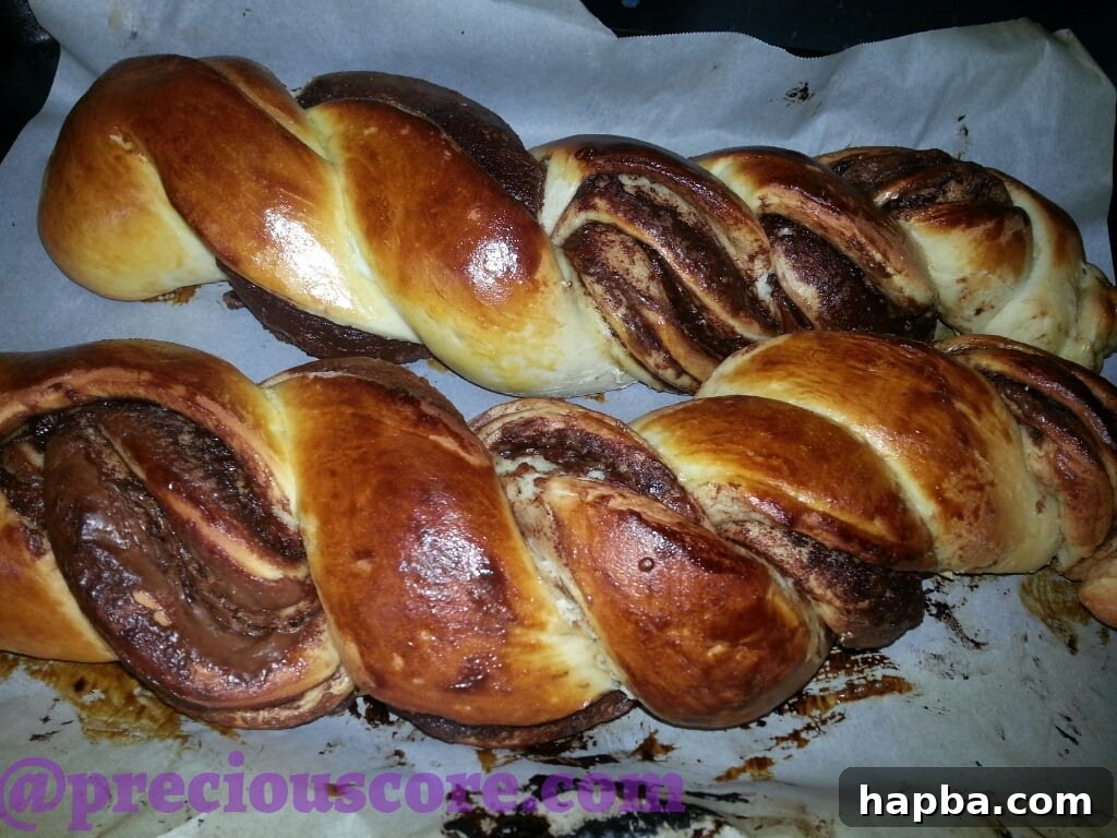 Foolproof Chocolate Bread Perfection 2 A freshly baked, beautifully braided Nutella bread loaf, golden brown and glistening, resting on a cooling rack.