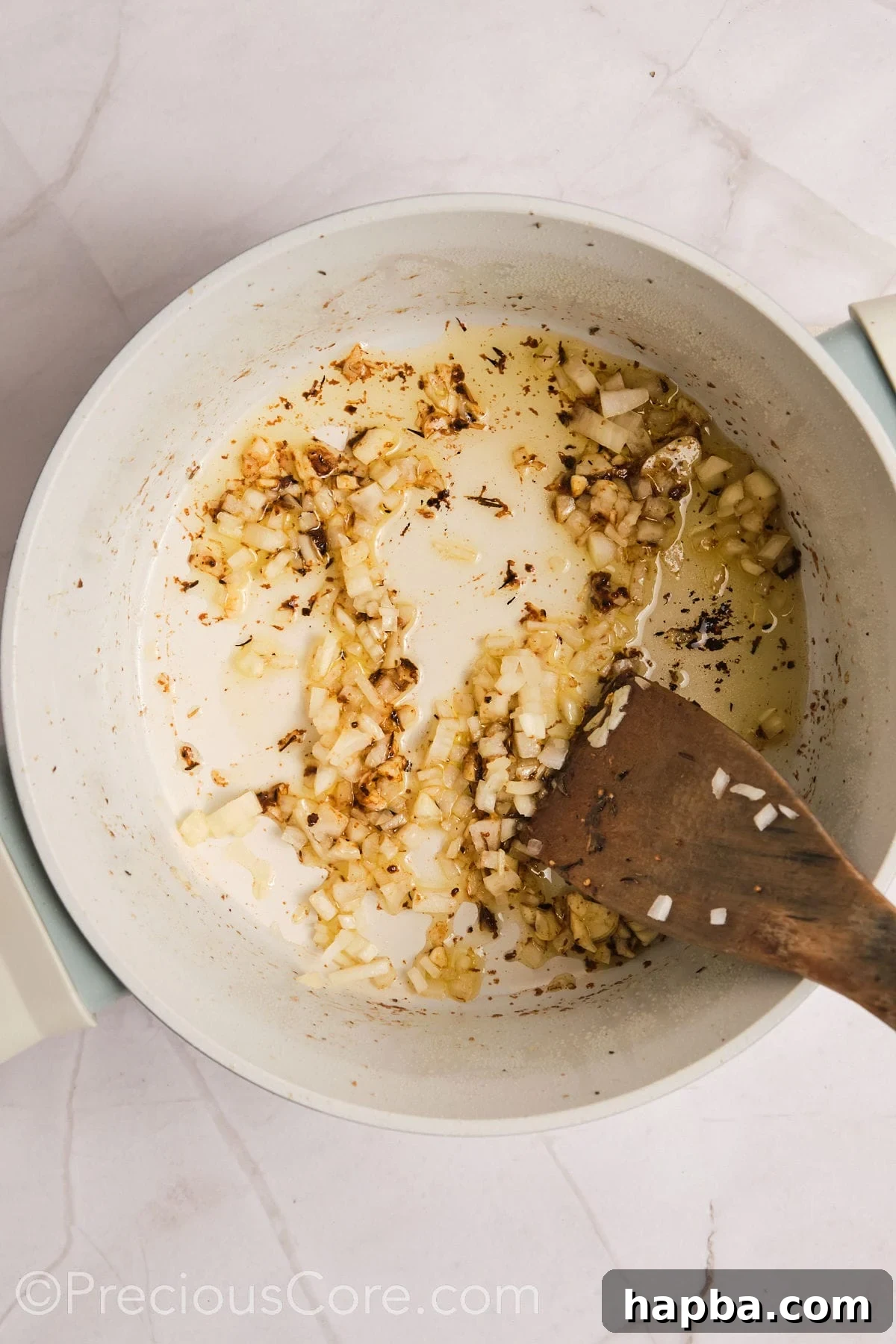 Velvety One-Pan Chicken Pasta 10 Sautéing onions and garlic in a pot.