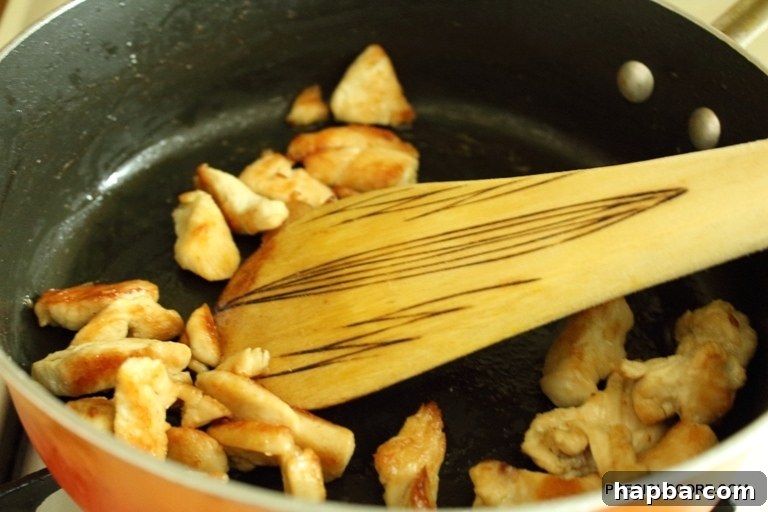 Sliced mushrooms being added to the hot pan to sauté