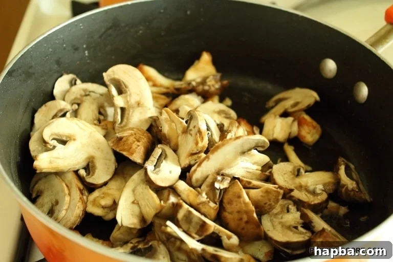 Mushrooms cooking in the pan, with garlic and ginger added for fragrance