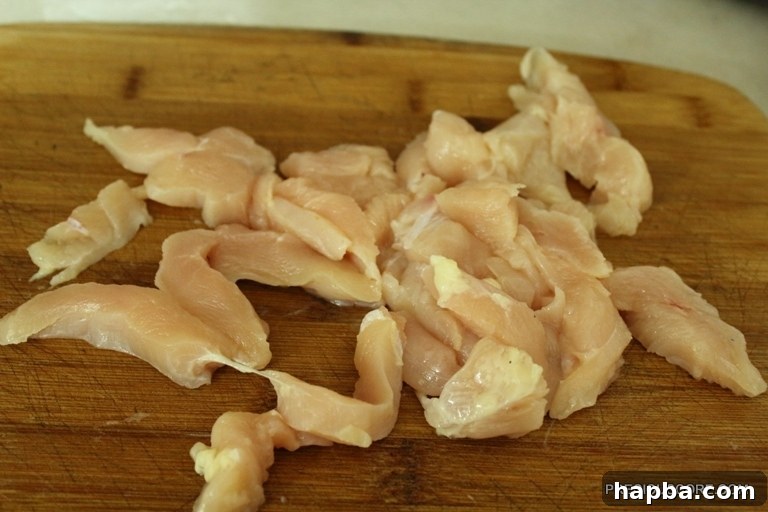 Chicken breasts cut into strips, ready for seasoning and cooking