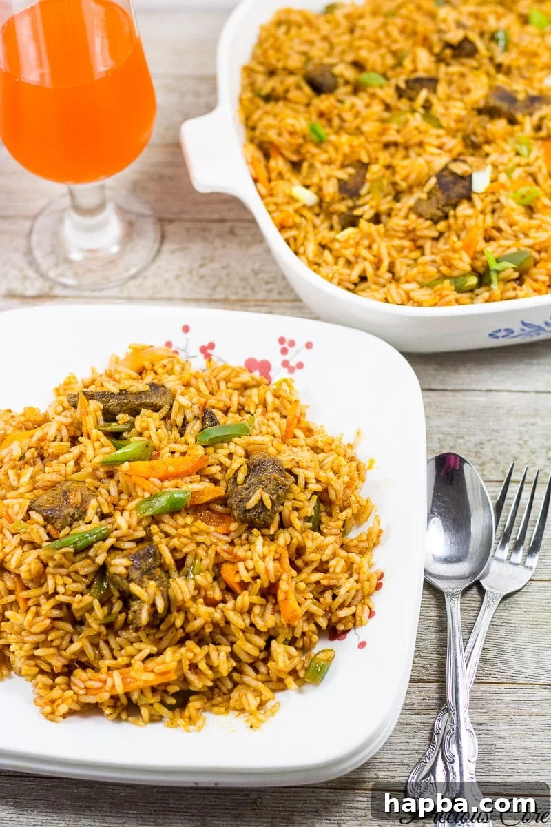 Jollof Rice on a plate with cutlery nearby.