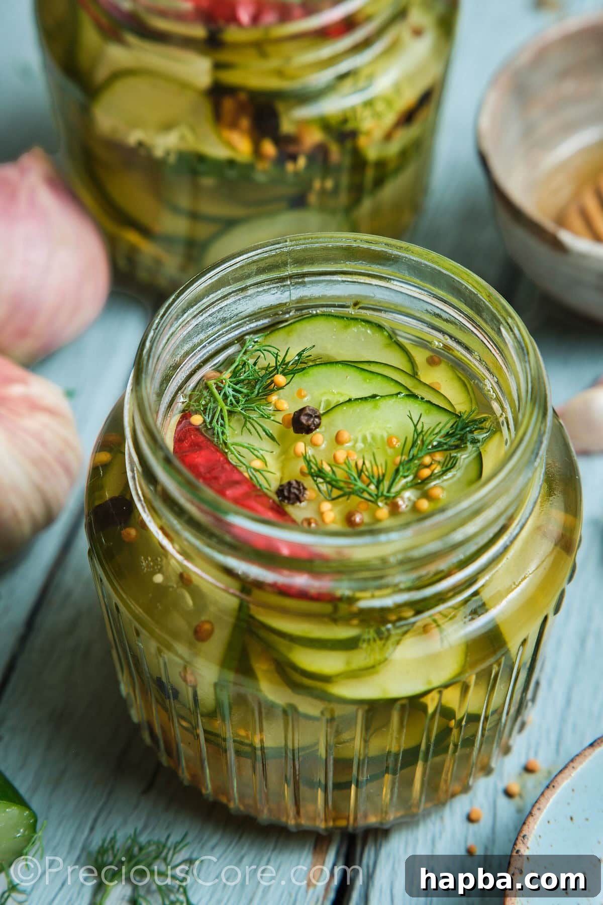 Speedy Zesty Pickles 2 Quick pickled cucumbers in a mason jar with peppercorns on top.