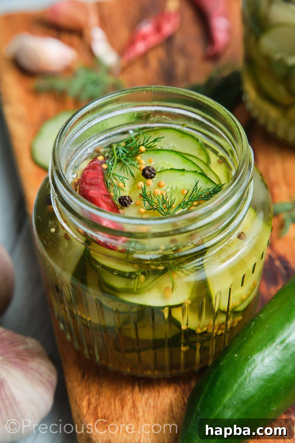 Speedy Zesty Pickles 6 Close-up shot of cucumber in a brine topped with peppercorns and dill.