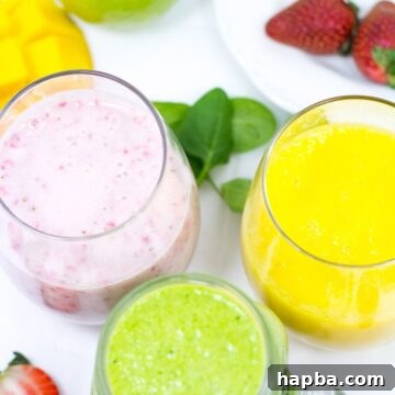 Three differently-colored smoothies in small glasses, presented invitingly.