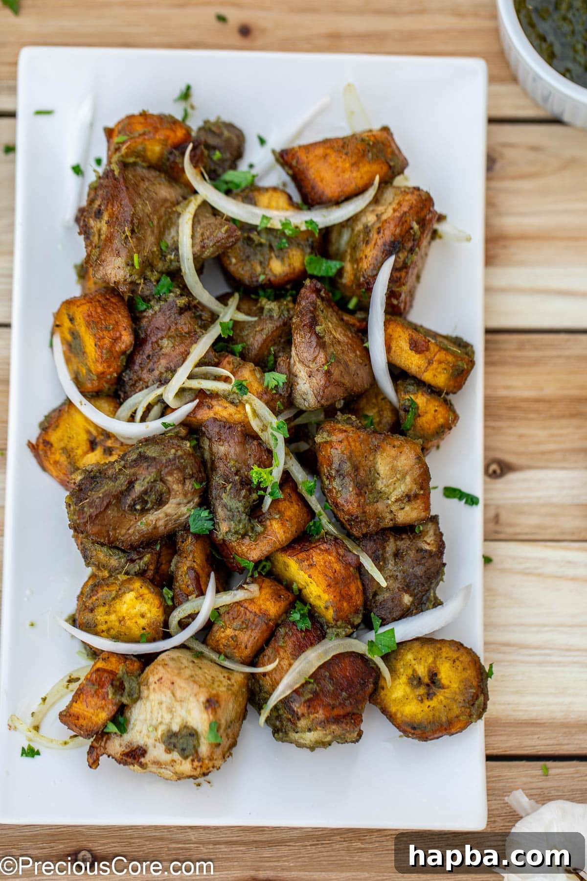 Fried pork and plantains topped with sliced onions.