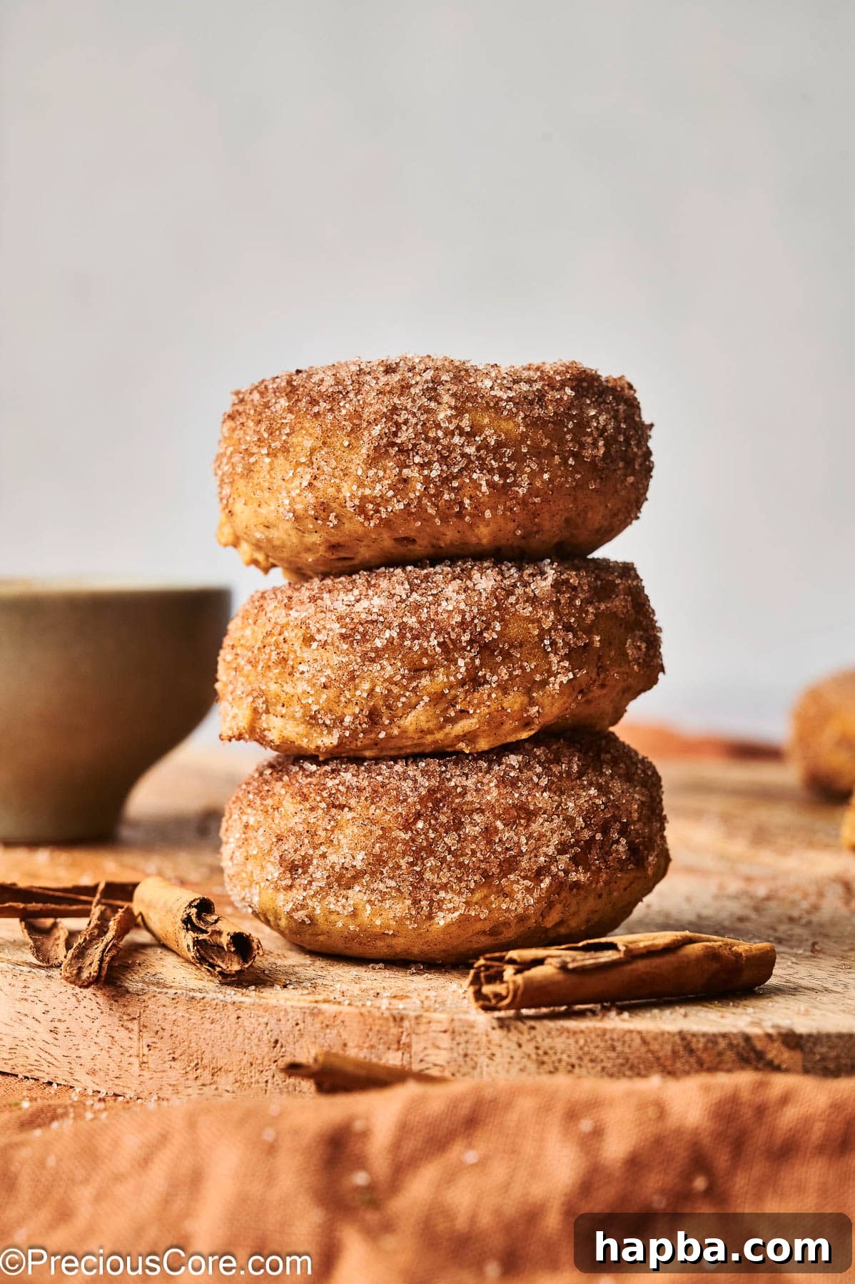 Three pumpkin spice doughnuts stacked on each other, showing their soft texture and golden-brown color.