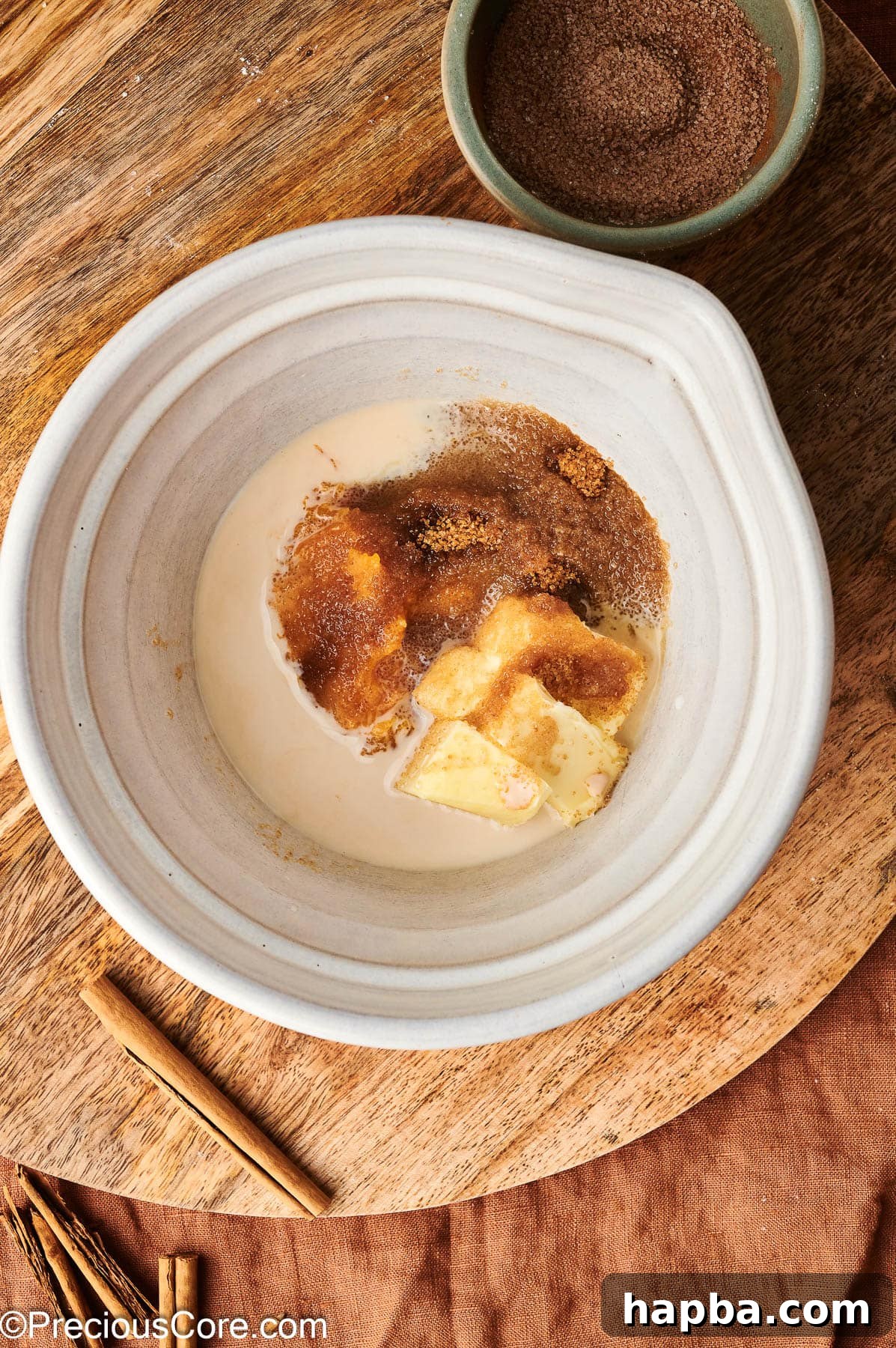 All wet ingredients for pumpkin doughnuts, including pumpkin puree, milk, and butter, combined in a bowl.
