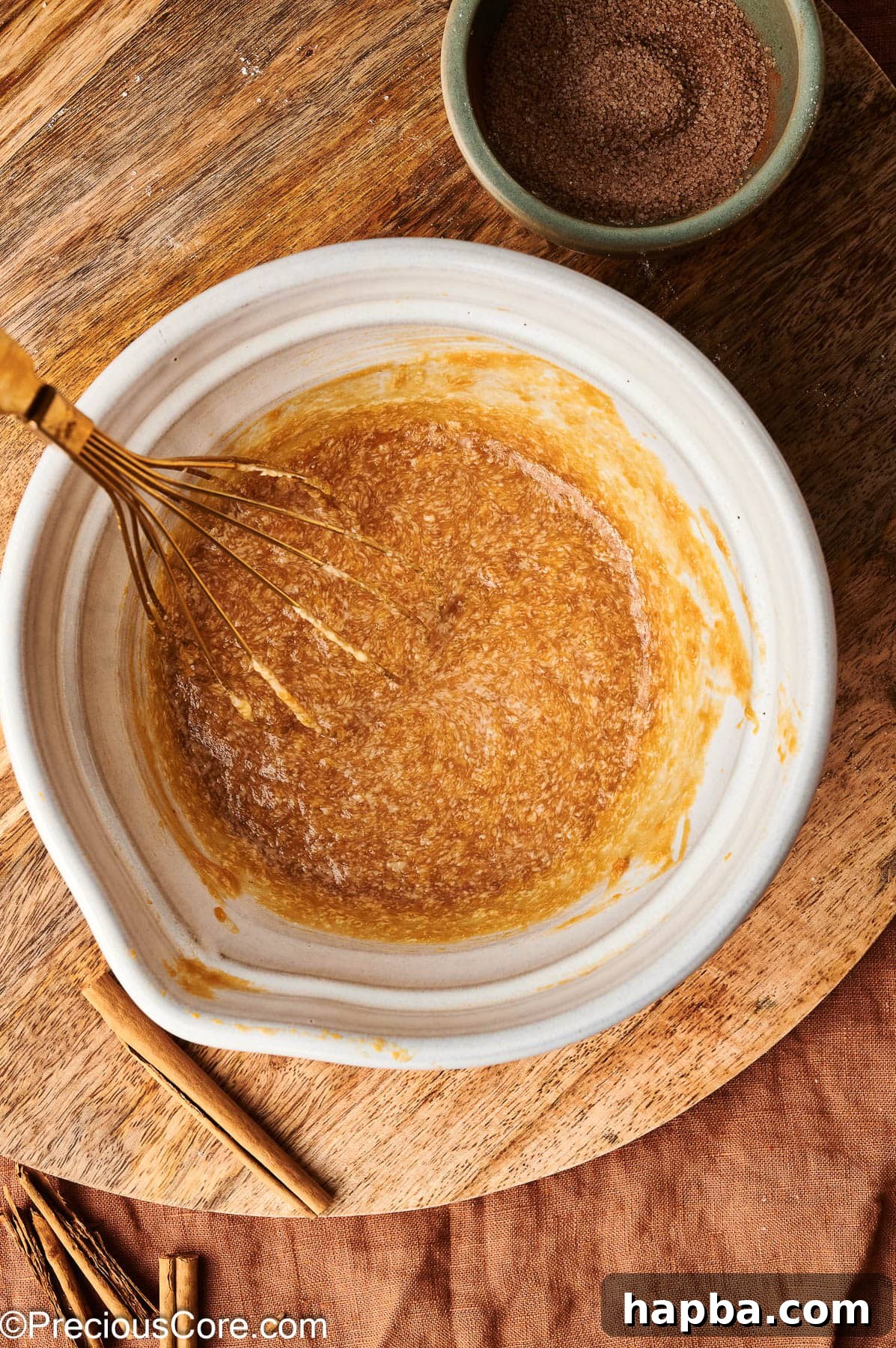 The whisked wet ingredients for pumpkin doughnuts, showing a smooth and homogenous mixture.