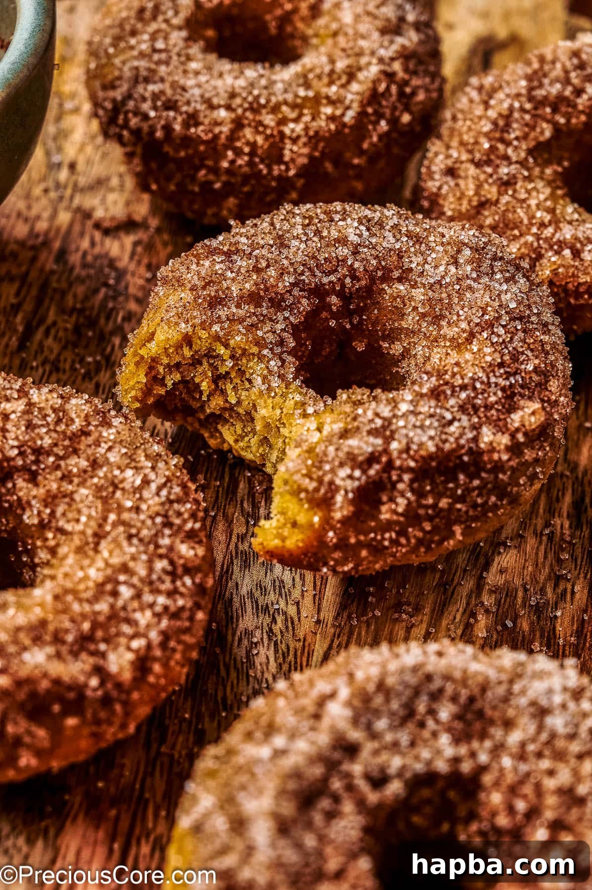 A selection of baked pumpkin doughnuts artfully arranged on a rustic wooden board, ready for serving.