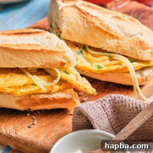 A French baguette stuffed with spaghetti omelette and cut in half.