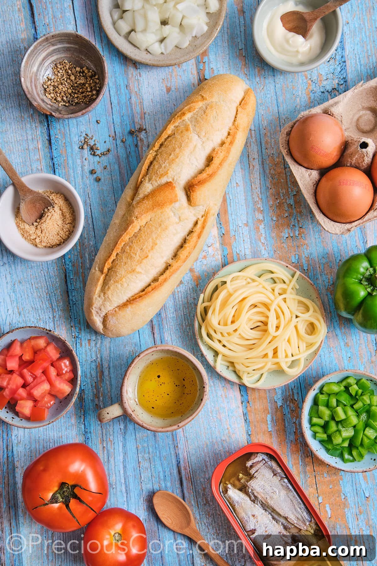 A flat lay of fresh ingredients laid out for making a homemade spaghetti omelette sandwich.