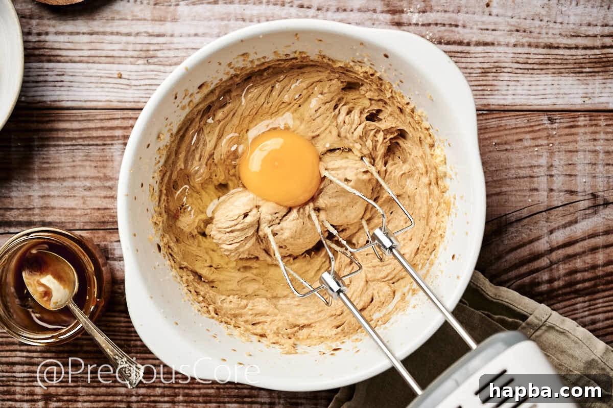 Salted Caramel Dream Cake 8 An egg being cracked into the butter and sugar mixture, ready to be incorporated.