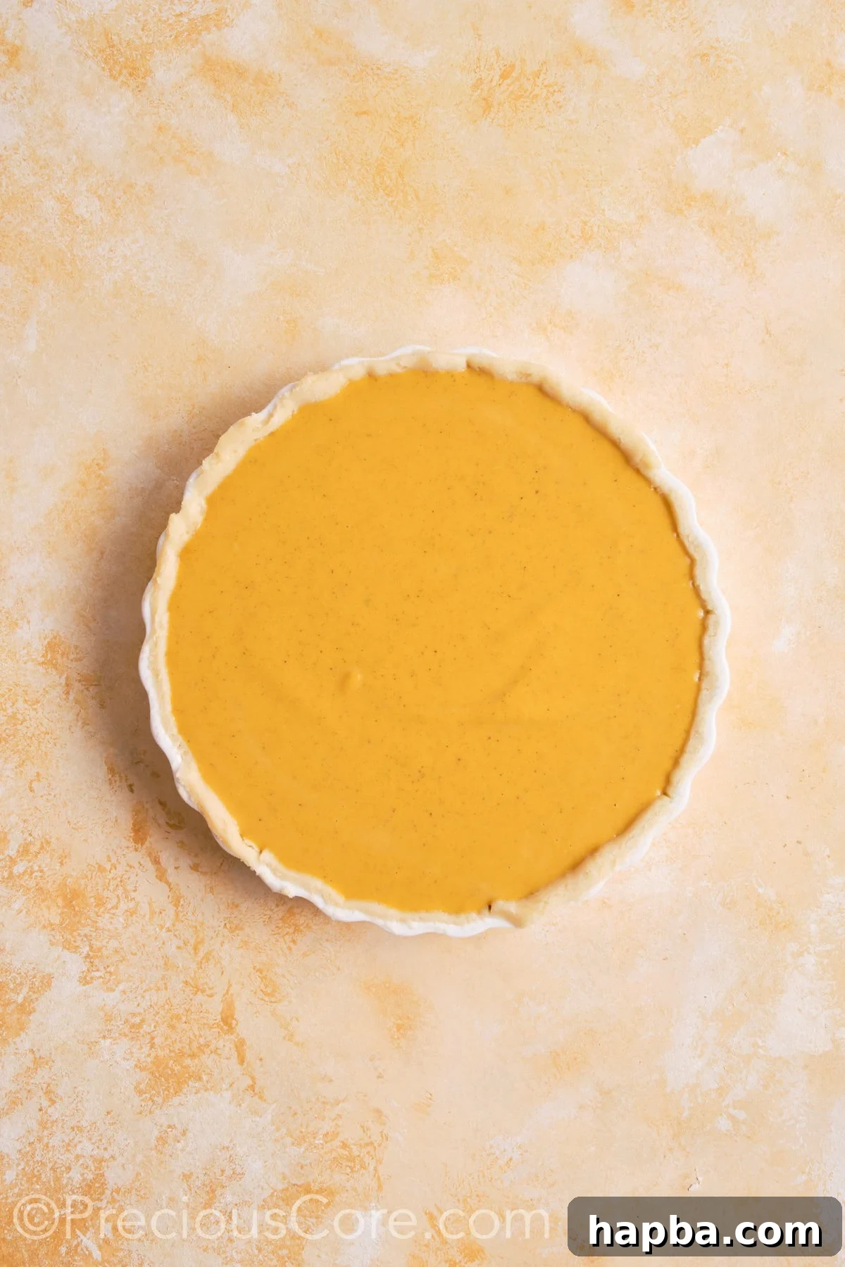 Pumpkin pie filling poured into unbaked pie crust.