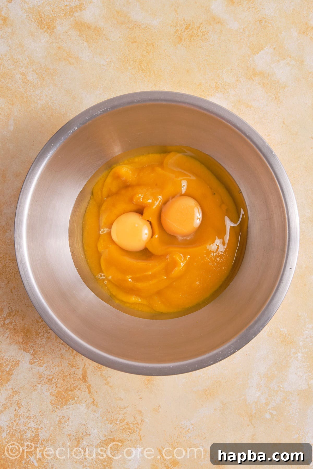 Eggs and pumpkin puree in a bowl.