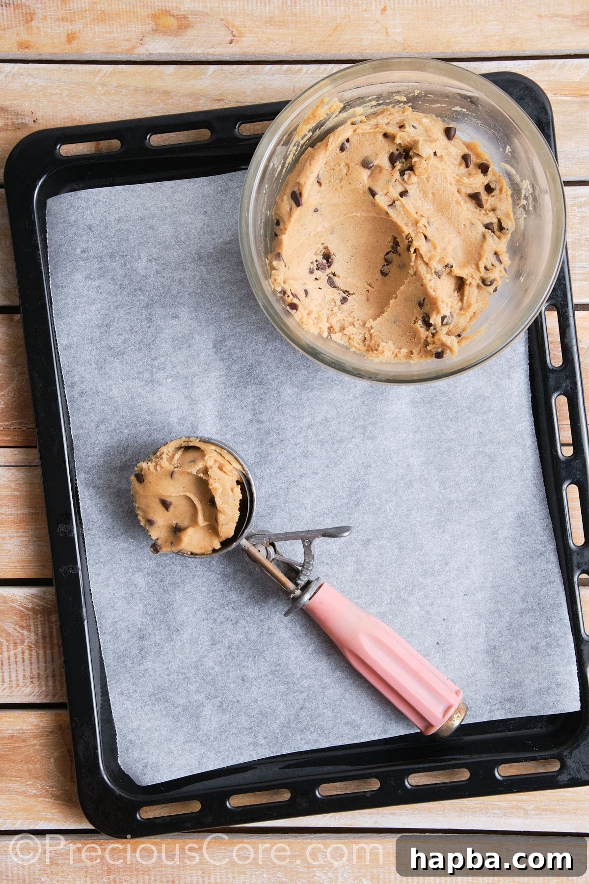 A cookie scoop filled with cinnamon chocolate chip cookie dough, ready to be placed on a baking sheet.