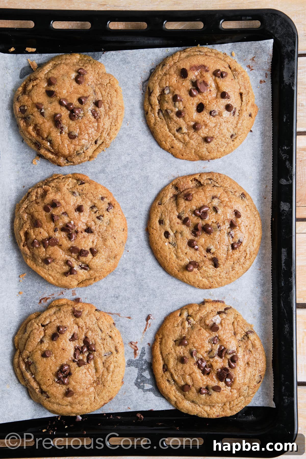 Six freshly baked cinnamon chocolate chip cookies arranged on a baking sheet.